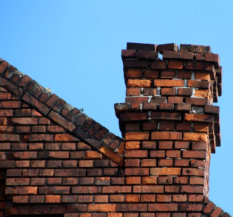 Damaged chimney on an Highland Beach home showing cracks and missing mortar